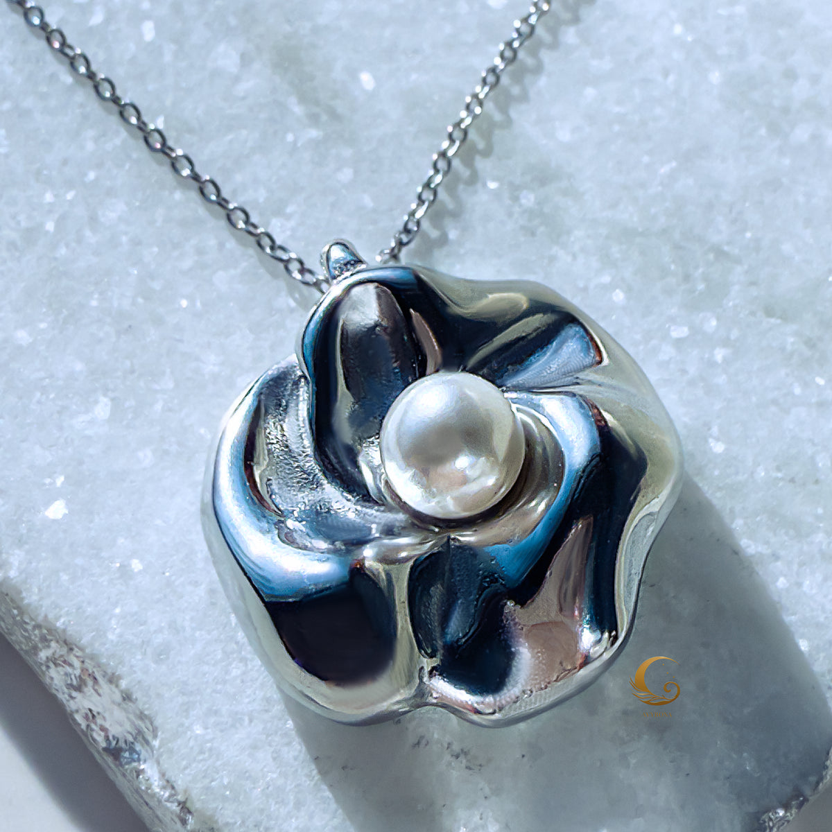 Straight-on view of silver flower necklace with centered luminous pearl