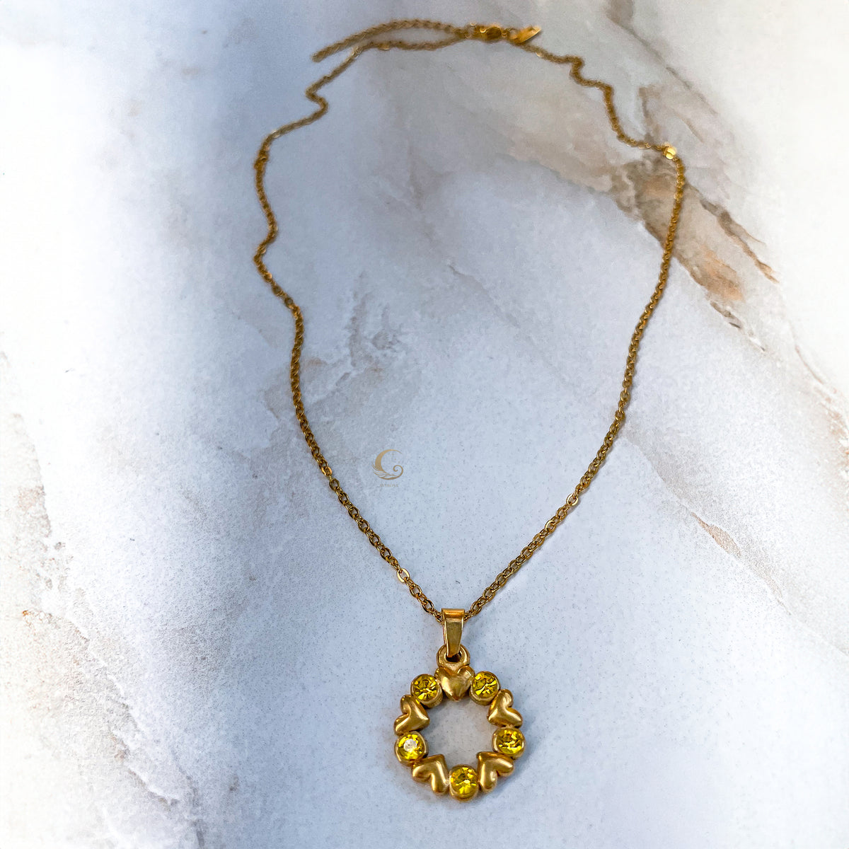 Solara necklace displayed flat with full chain and extender, marble surface beneath